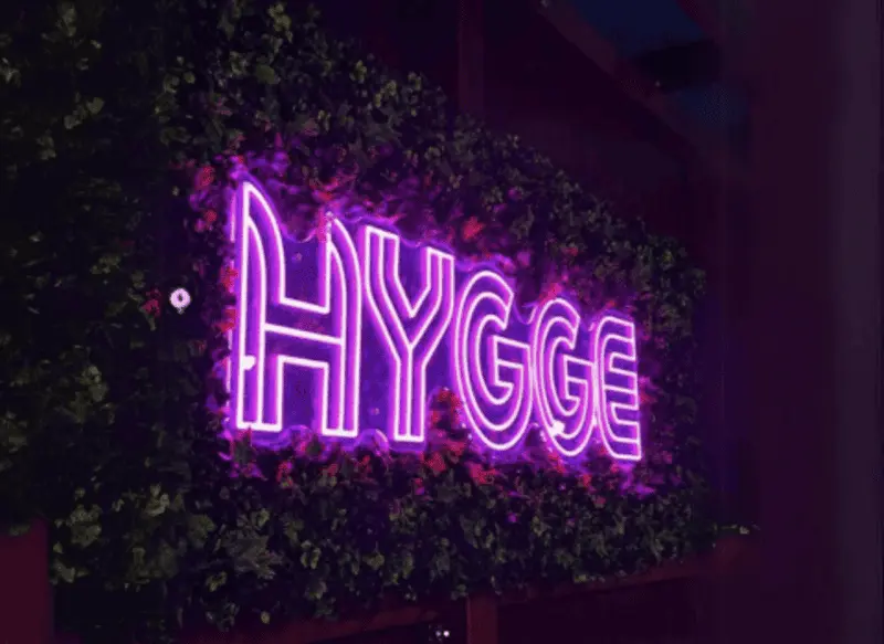Fialový neonový nápis Hygge v zeleni — realizace Neonworld