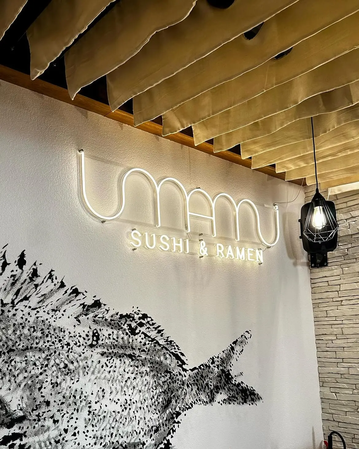 Neonový nápis Umami Sushi & Ramen v interiéru — realizace Neonworld