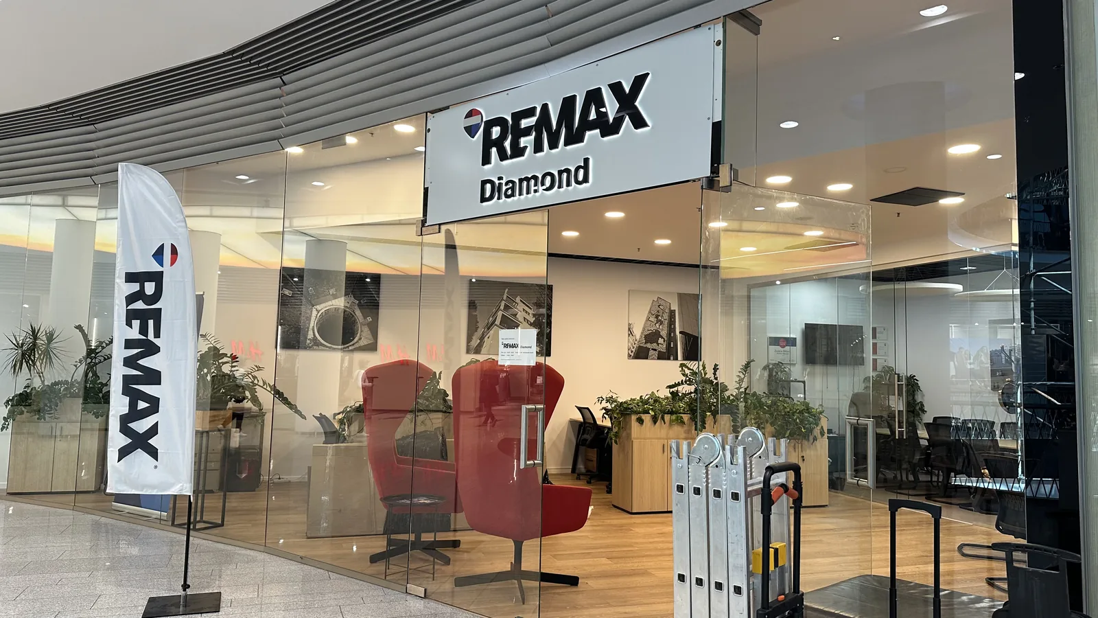 Světelný nápis RE/MAX Diamond nad vstupem do kanceláře v obchodním centru — realizace Neonworld